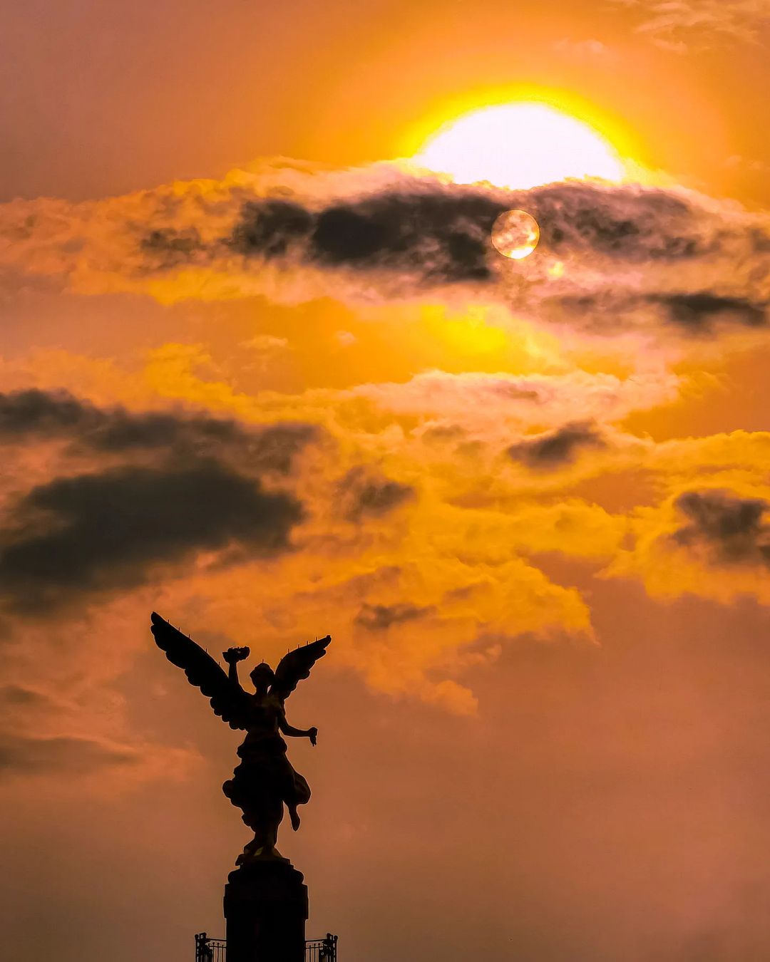 La silueta del Ángel de la Independencia y el Sol en una tarde cualquiera en la CDMX